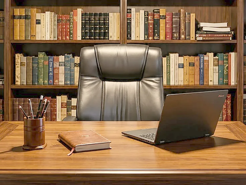 Bureau de direction avec fauteuil en cuir, ordinateur portable et bibliothèque