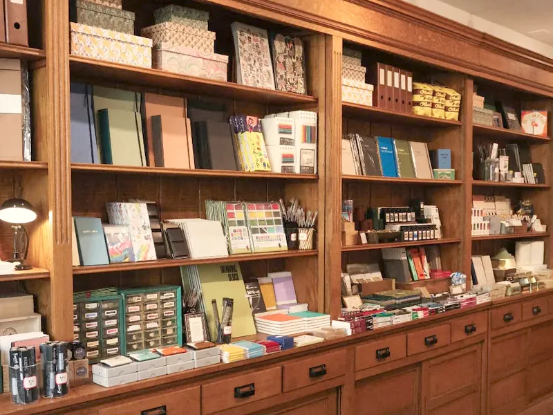 Étagères de librairie-papeterie garnies de cahiers et de fournitures